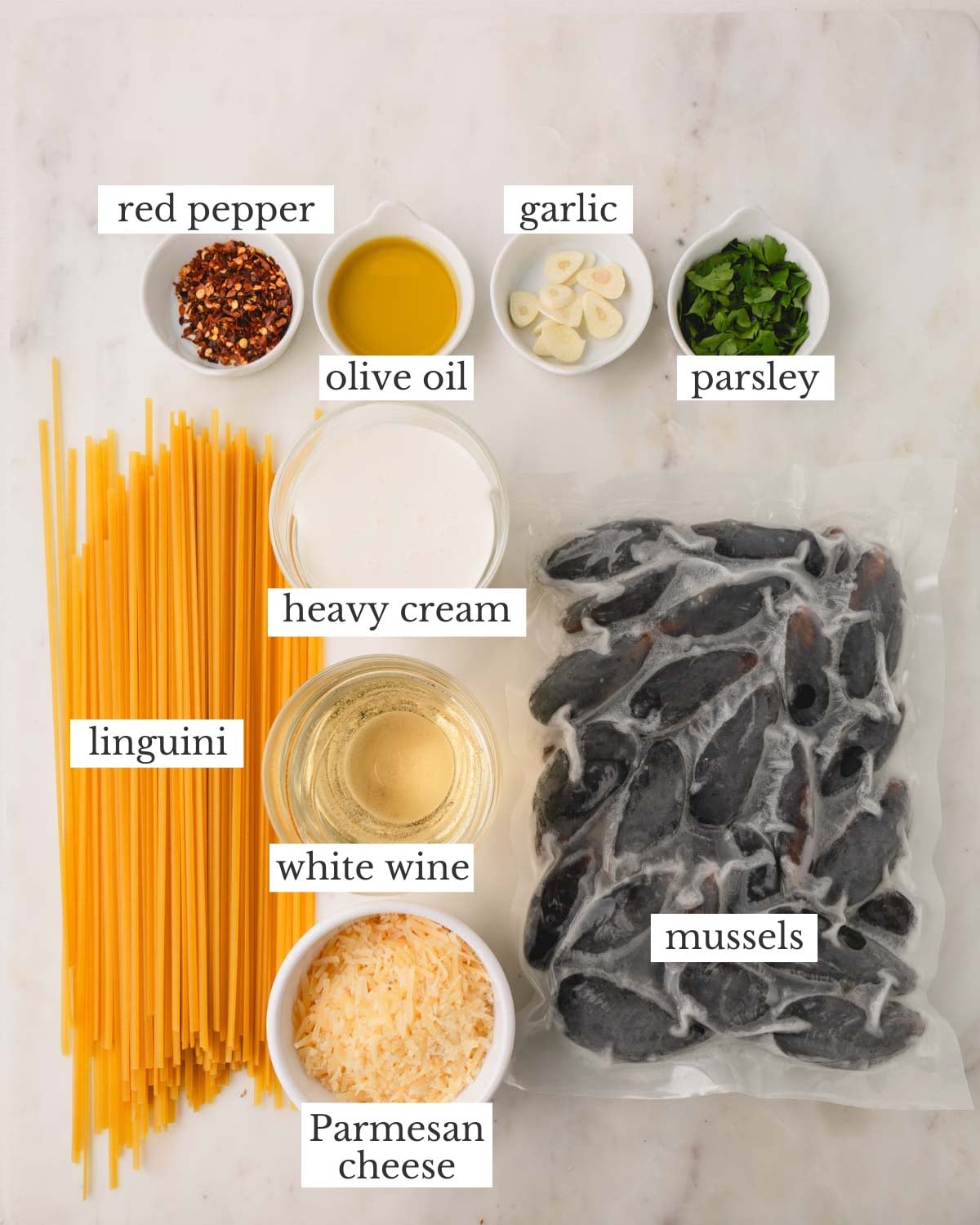 Ingredients for pasta with mussels which include, heavy cream, Parmesan cheese, white wine, heavy cream, olive oil, red chili flakes, garlic, parsley, and mussels.
