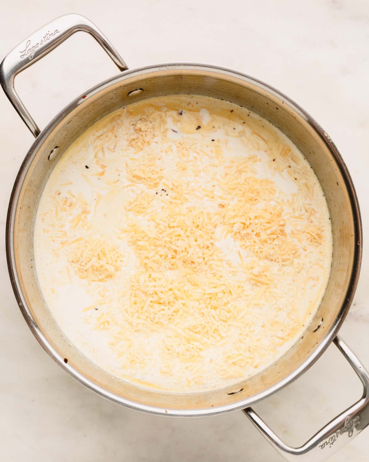 Heavy cream and parmesan cheese are added to the saute pan.