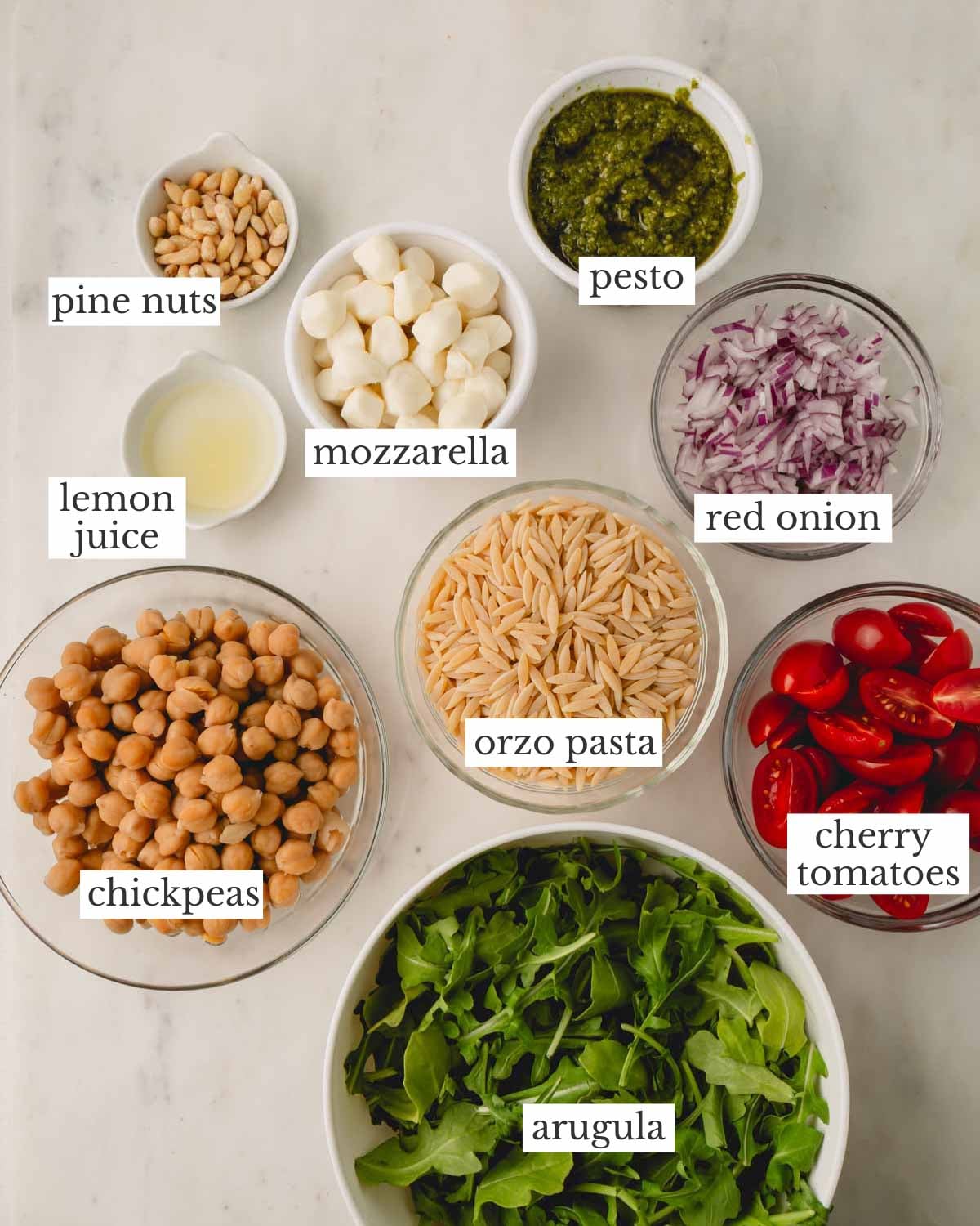 Ingredients for pesto orzo pasta salad in individual bowls.
