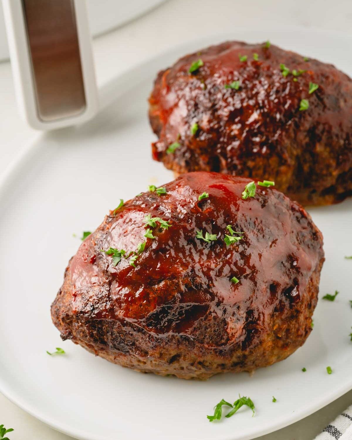 Cooked air fryer meatloaves on a plate.