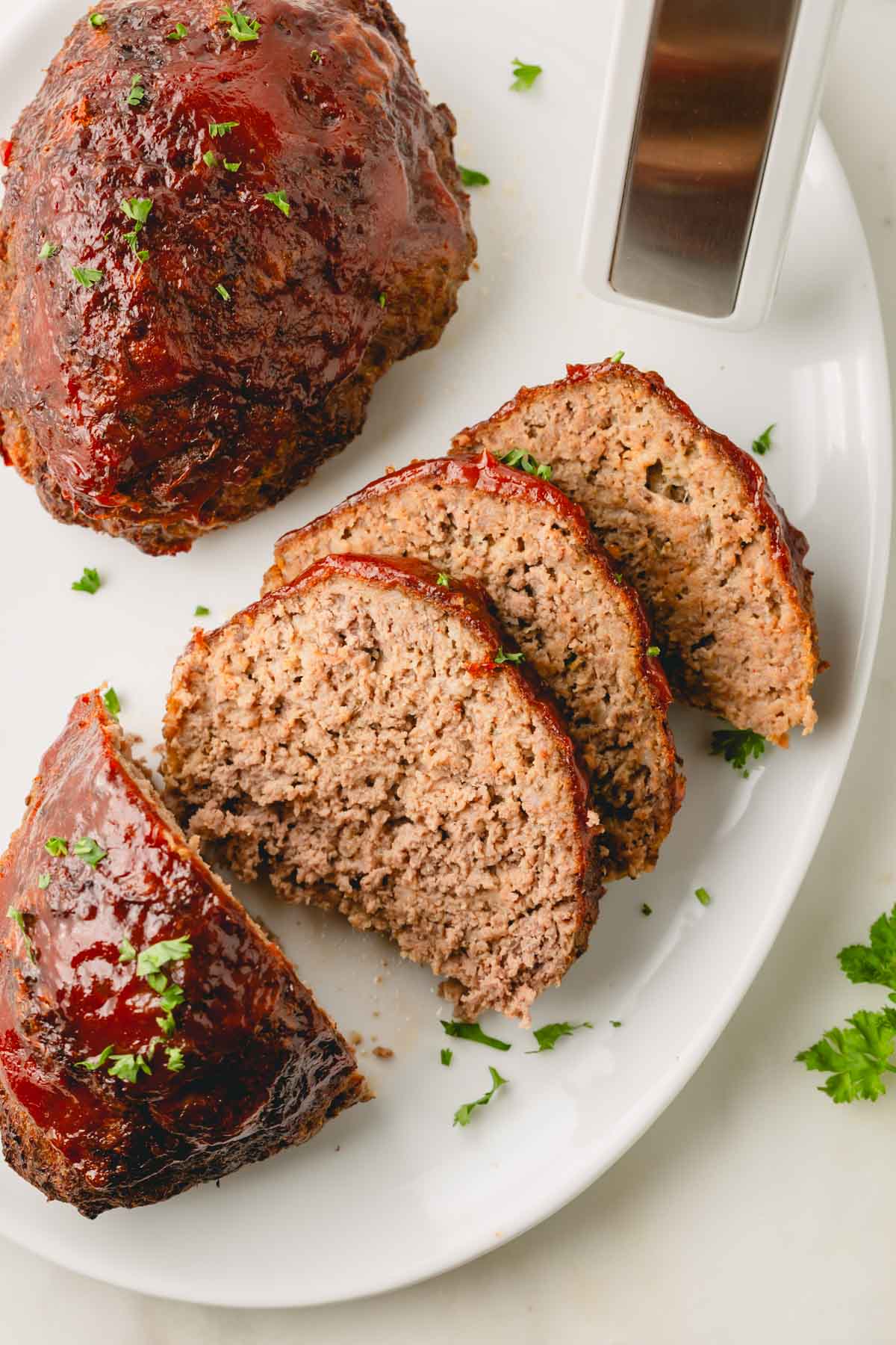 Sliced air fryer meatloaf on a white plate.