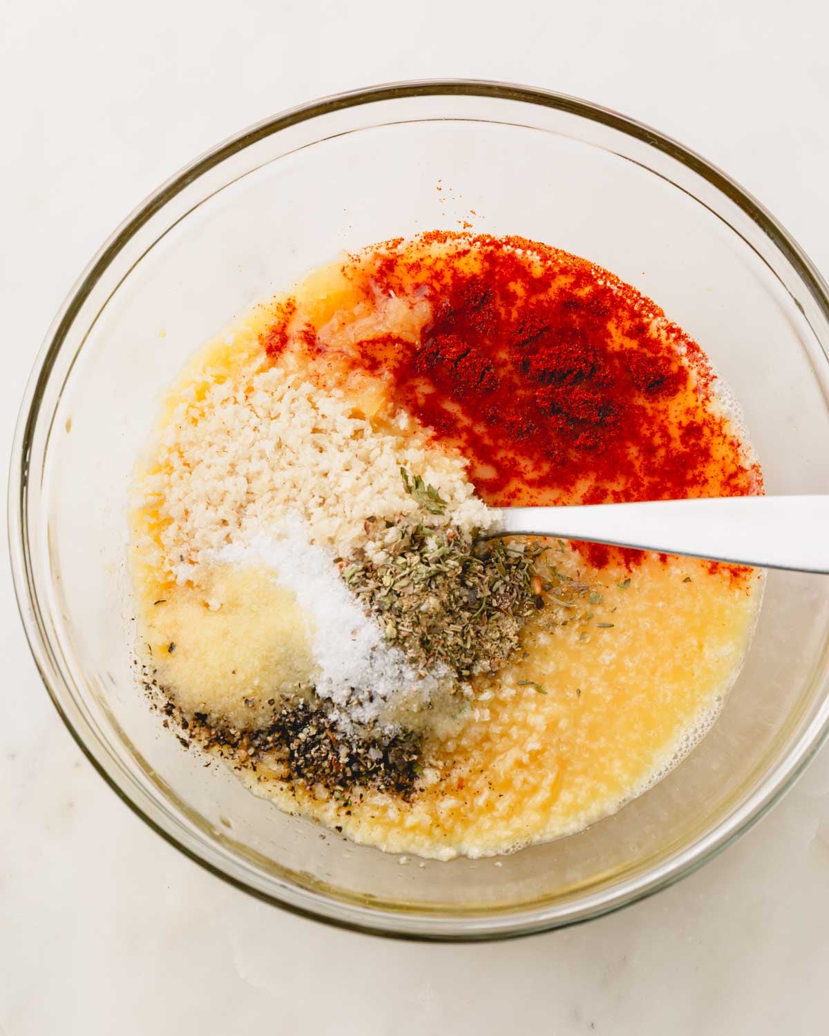 A glass bowl with the wet ingredients for air fryer meatloaf and a fork to mix.
