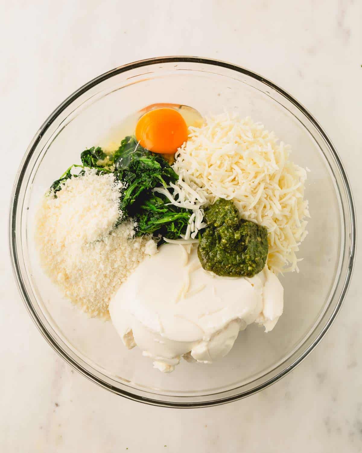 A glass bowl with ricotta cheese mixture.