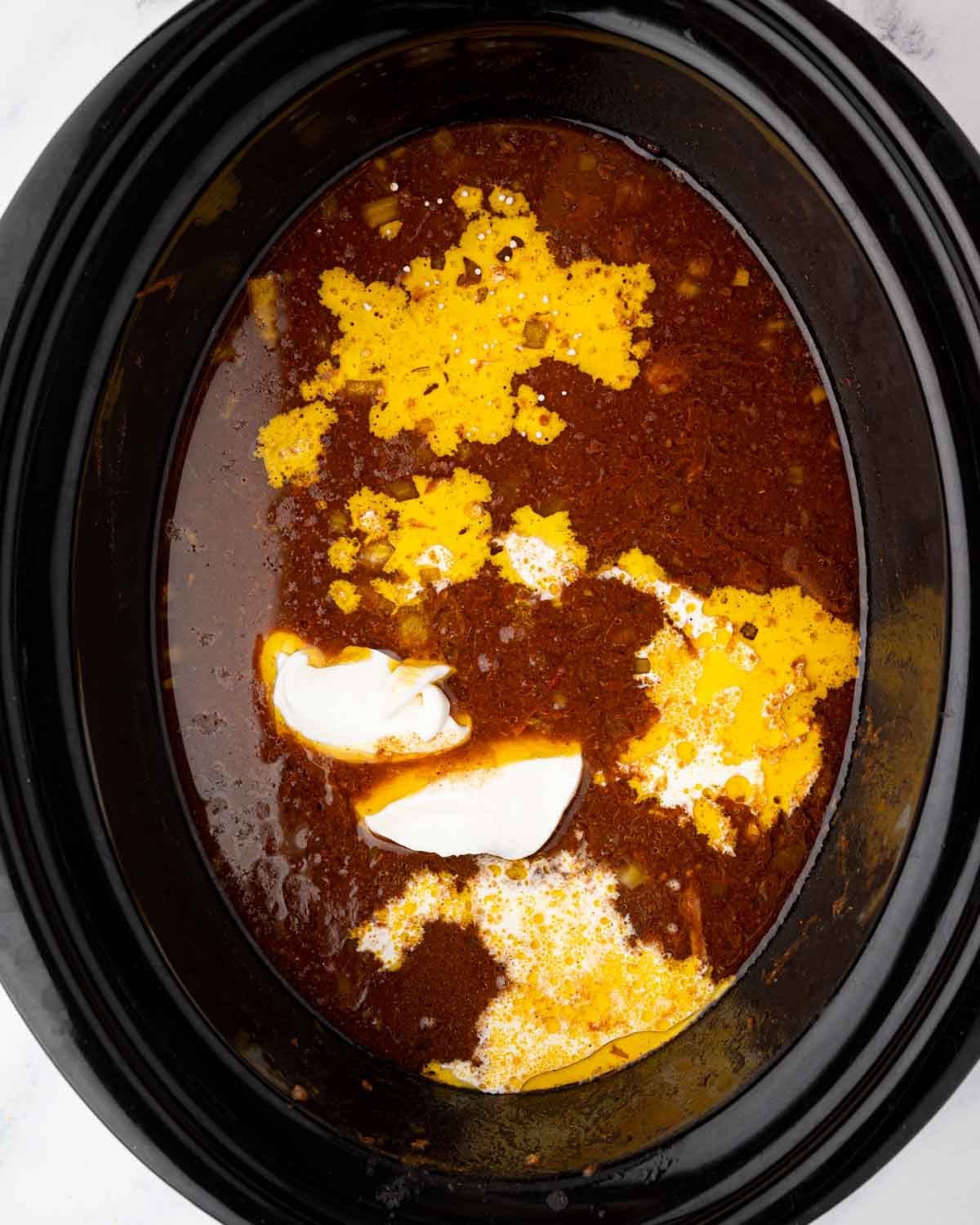 Cream and yogurt are added to slow cooker butter chicken.