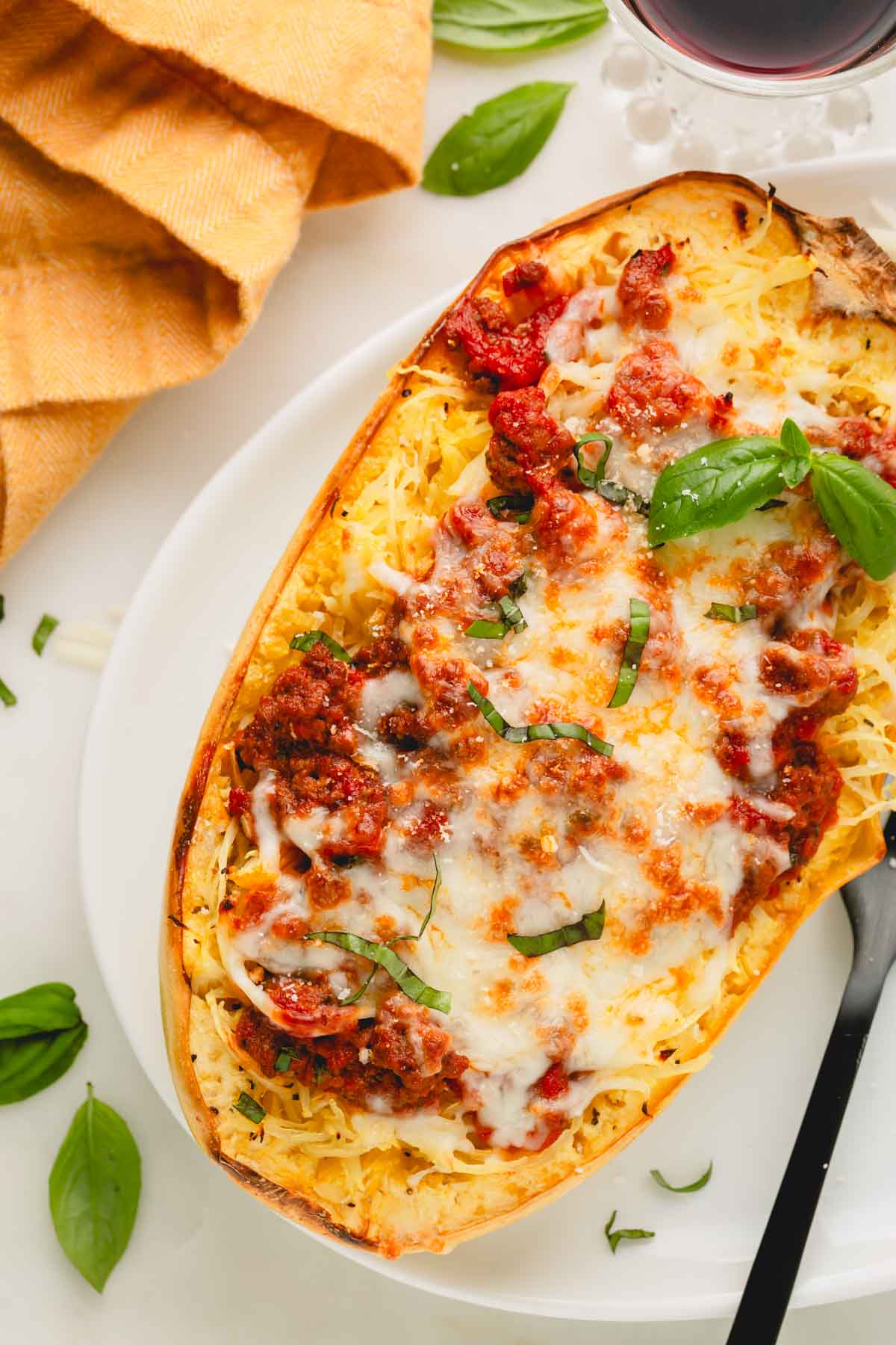 Spaghetti squash with meat sauce on a white plate with a black fork.