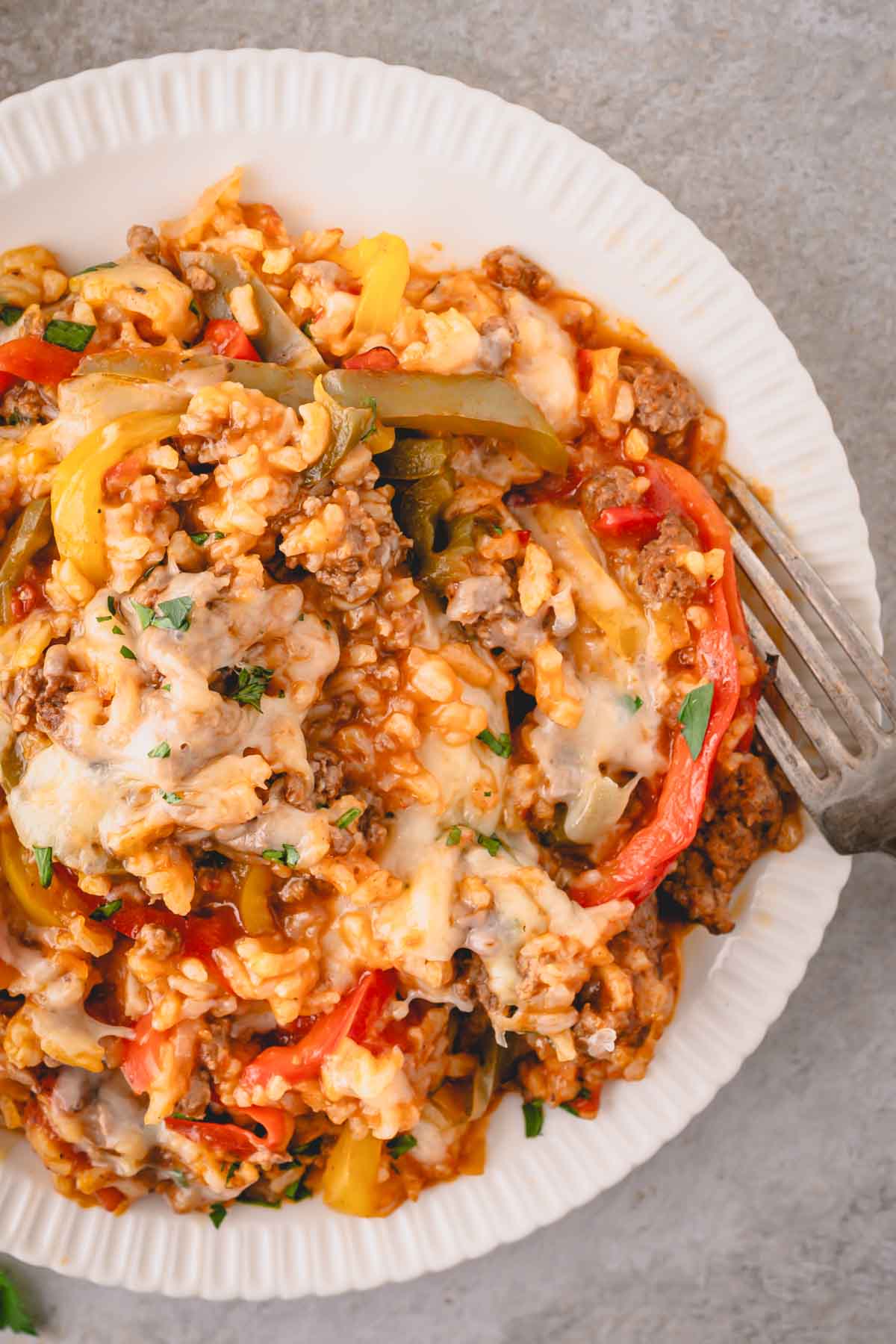 A white plate with unstuffed pepper skillet and a fork.
