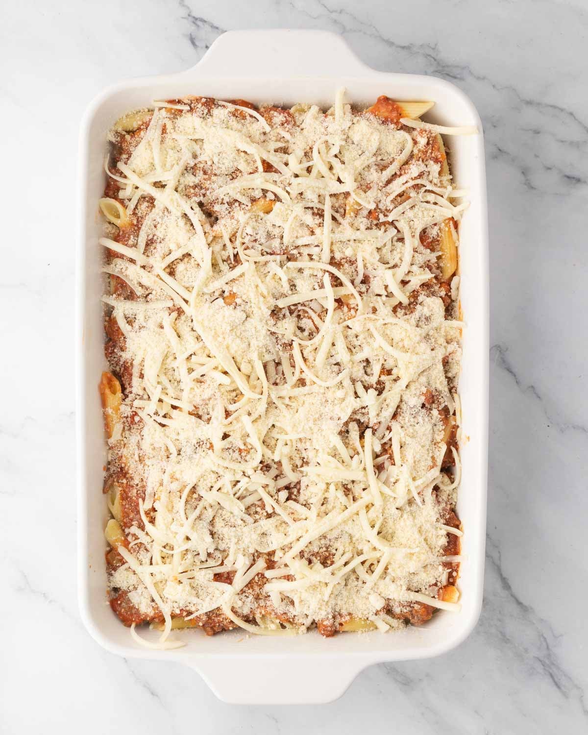 Parmesan cheese and mozzarella cheese are added to the meat sauce on top.