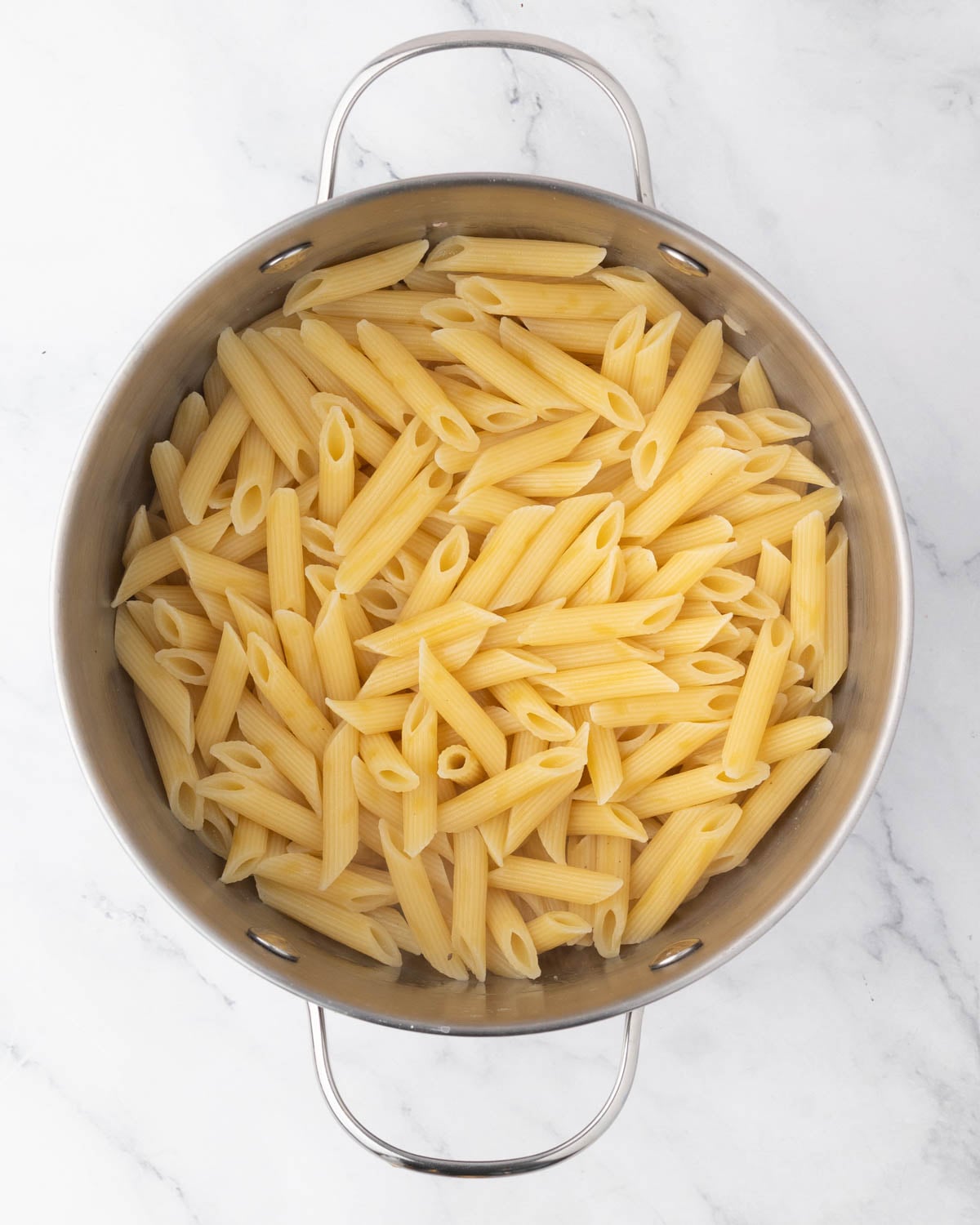 A pot boiling penne noodles.