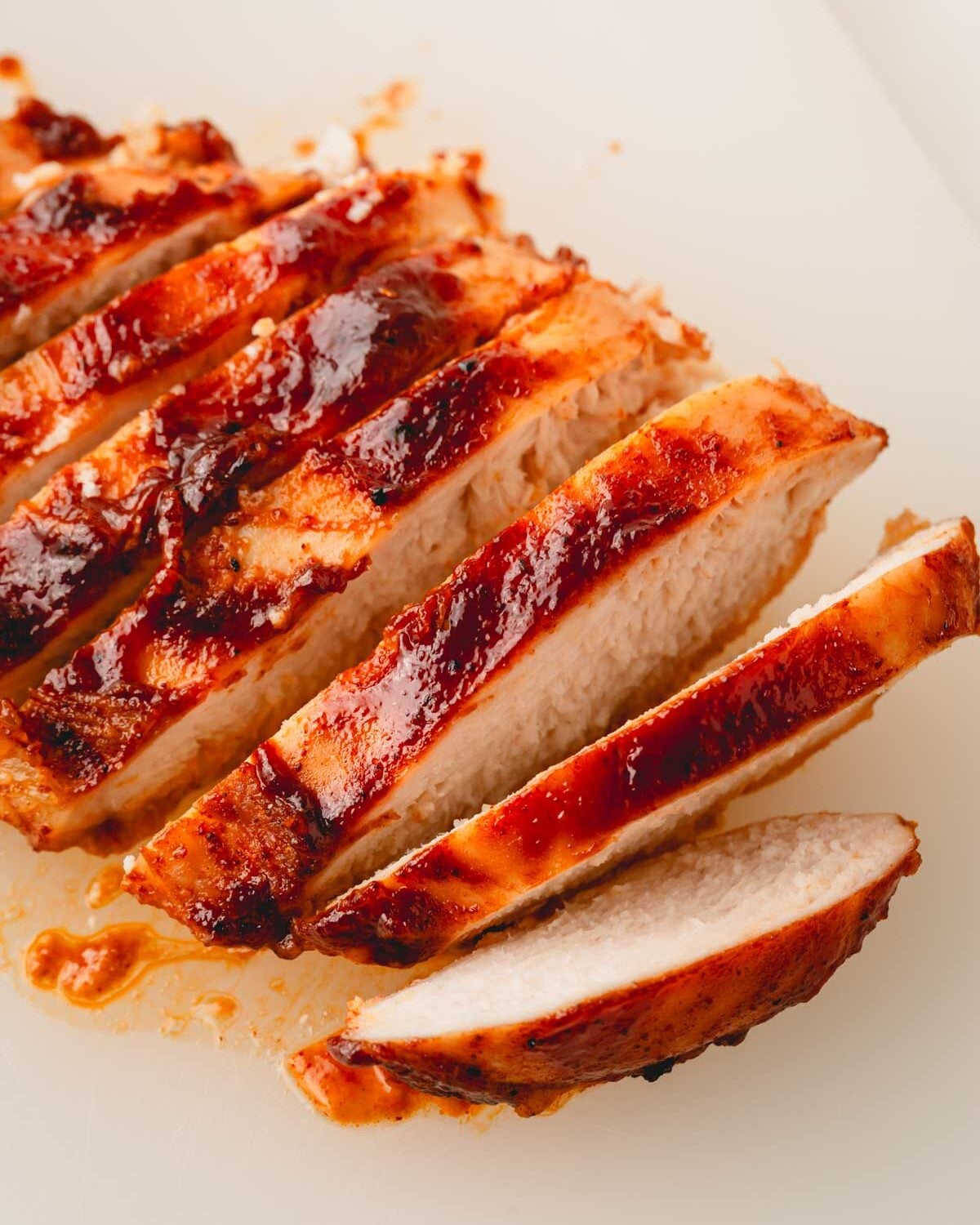 Close up image of a sliced bbq chicken breast that was baked in the oven.