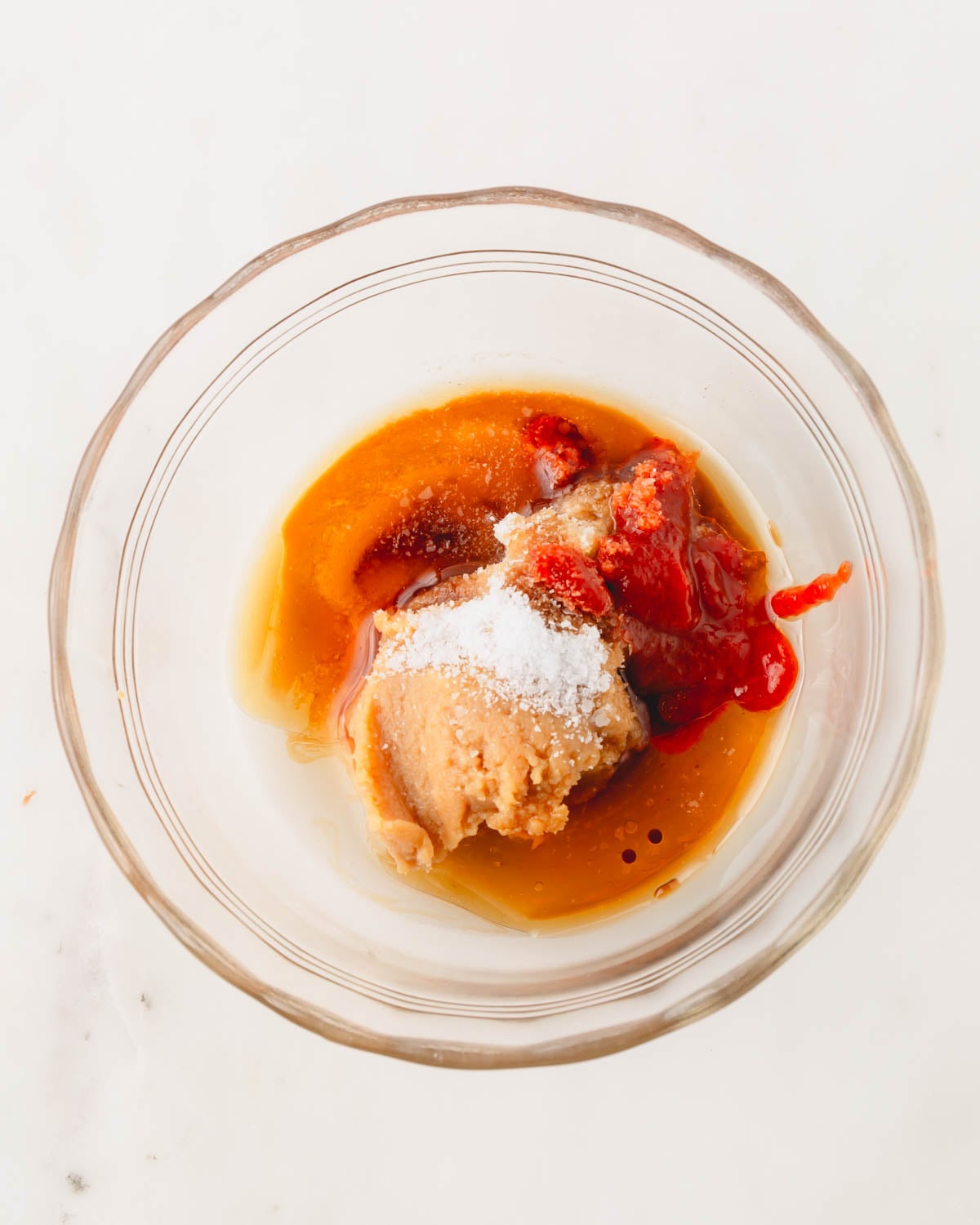 A glass bowl with the ingredients for the miso glaze sauce.