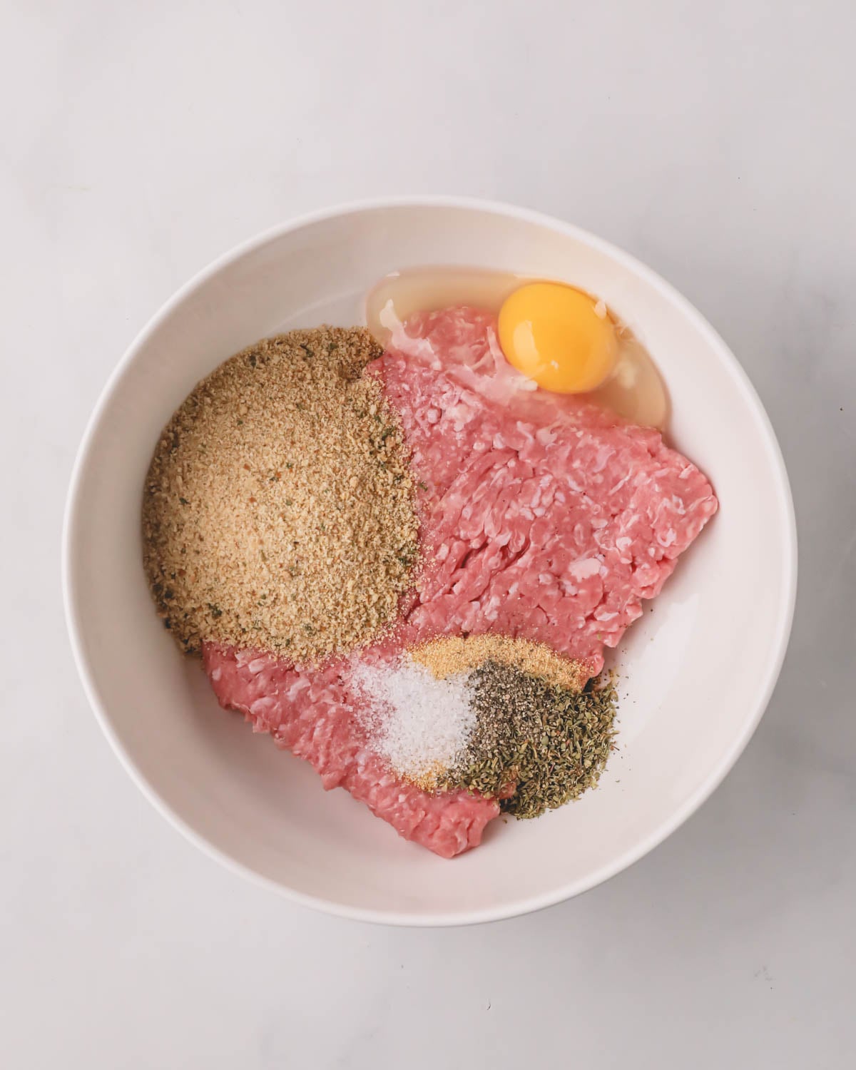 A white bowl with ingredients for air fryer turkey meatballs.