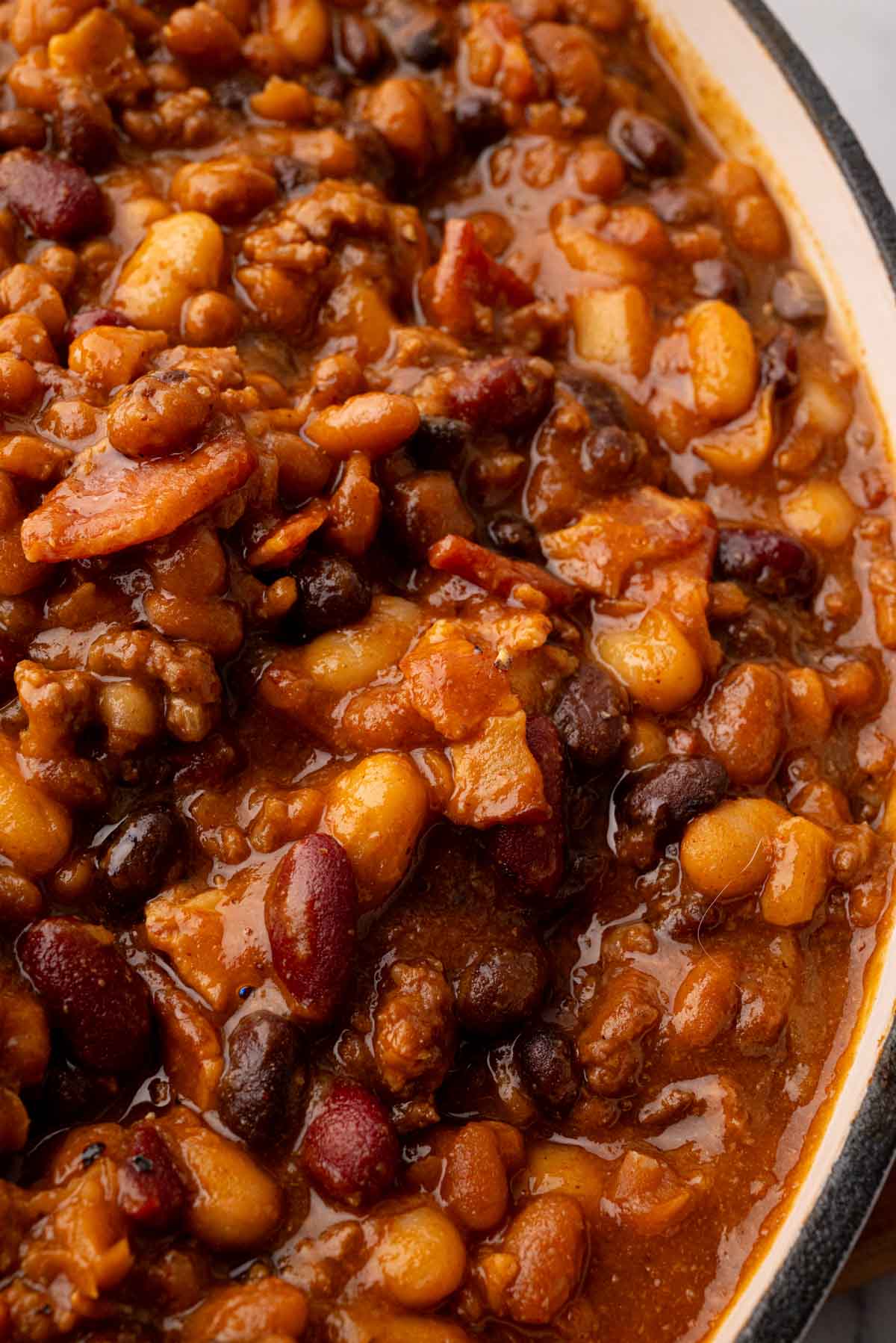 A close up image of cowboy baked beans in a white skillet.