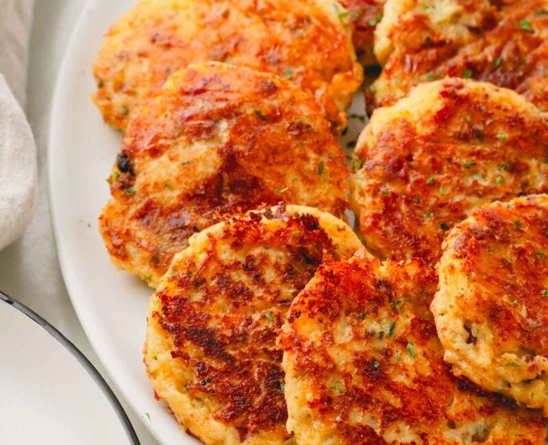 A white plate with fried mashed potato patties.