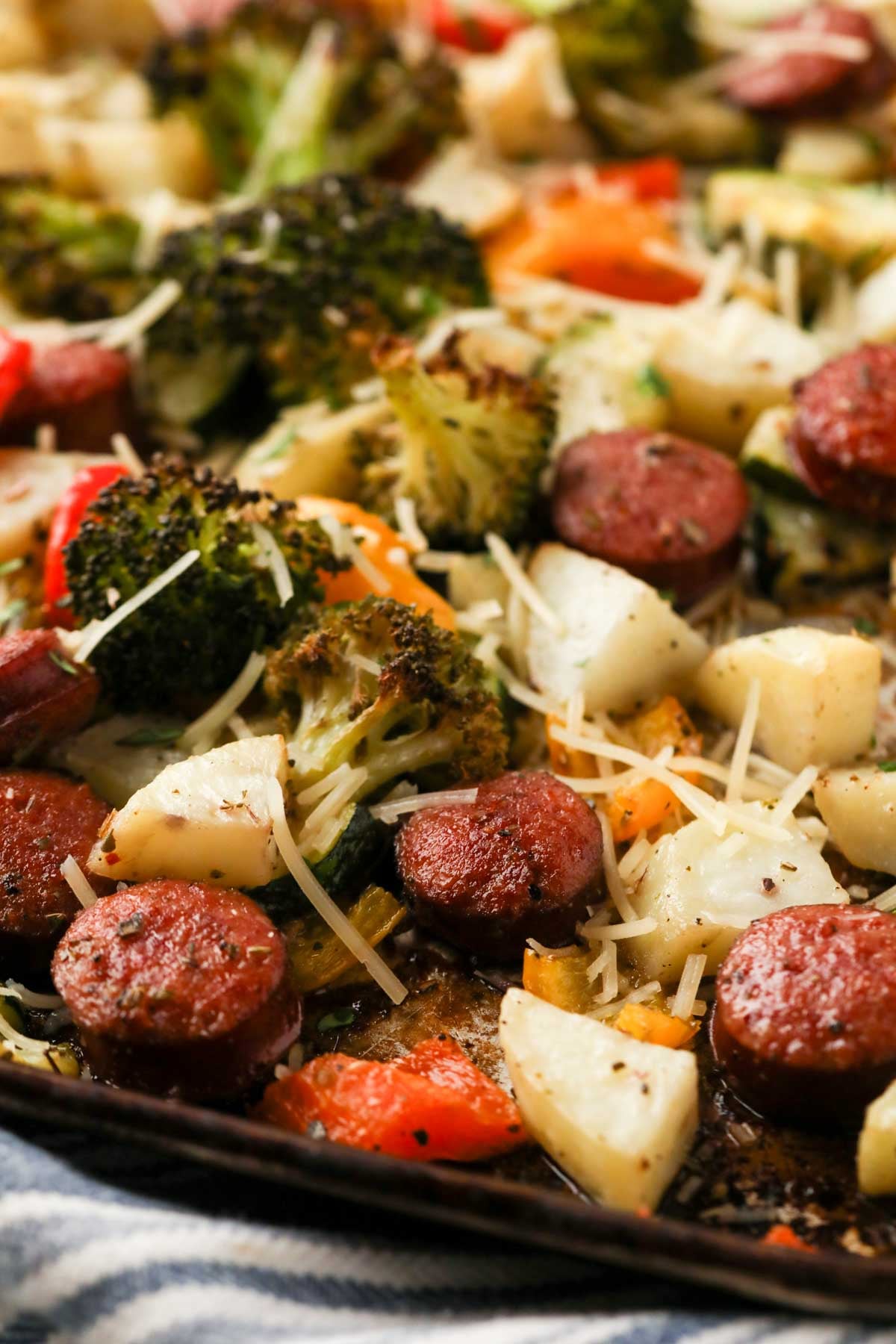 A close up image of sheet pan sausage and vegetables.