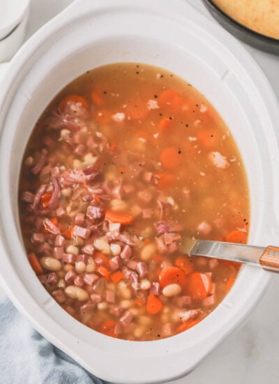 Overhead image of ham and beans in a slow cooker.