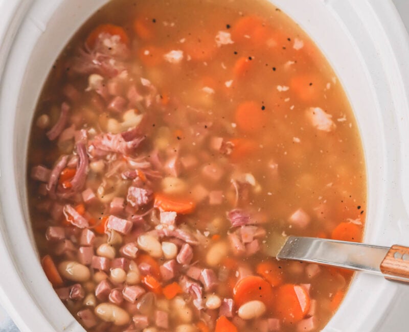 Overhead image of ham and beans in a slow cooker.