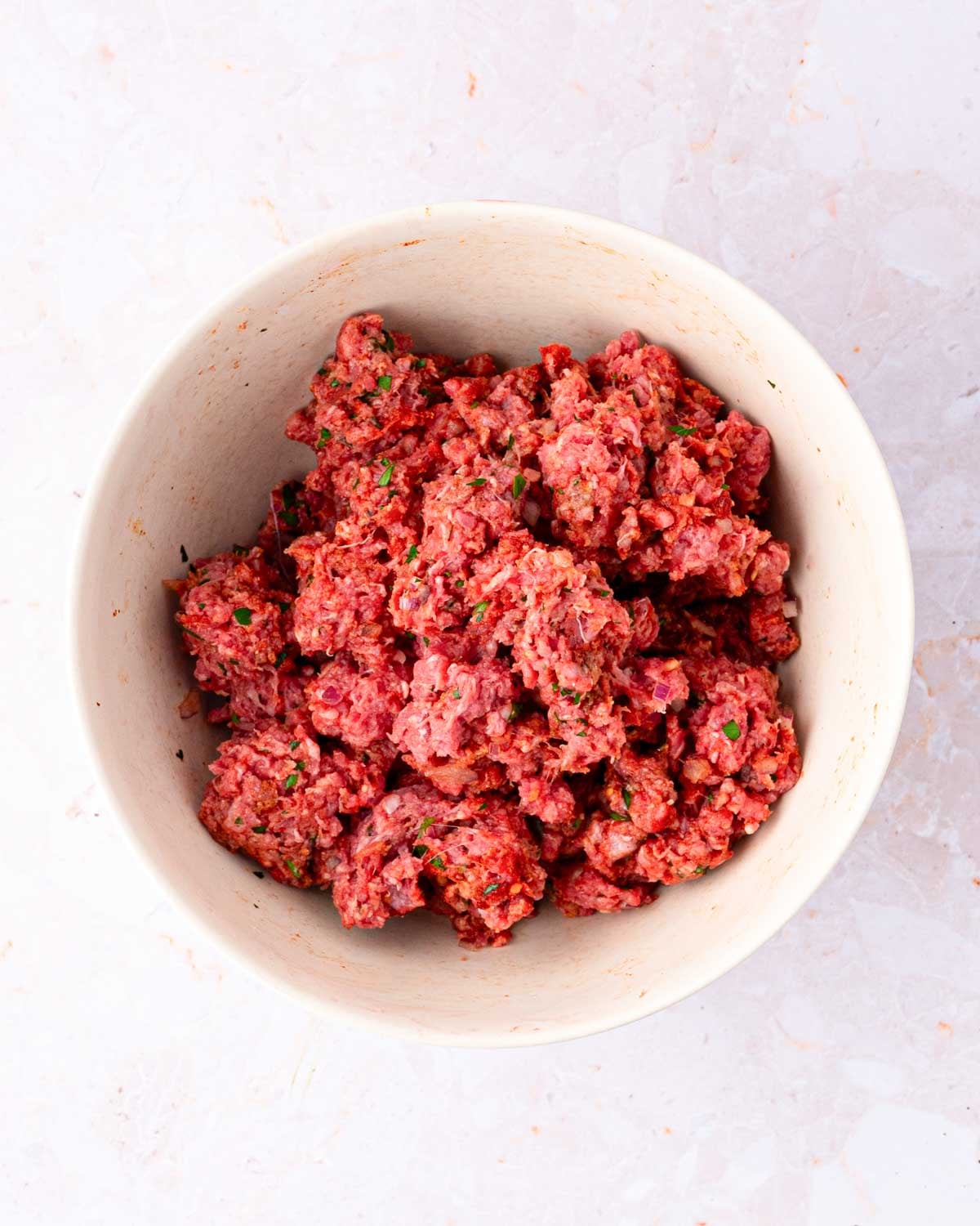 Mixed ground bison meat with seasonings.