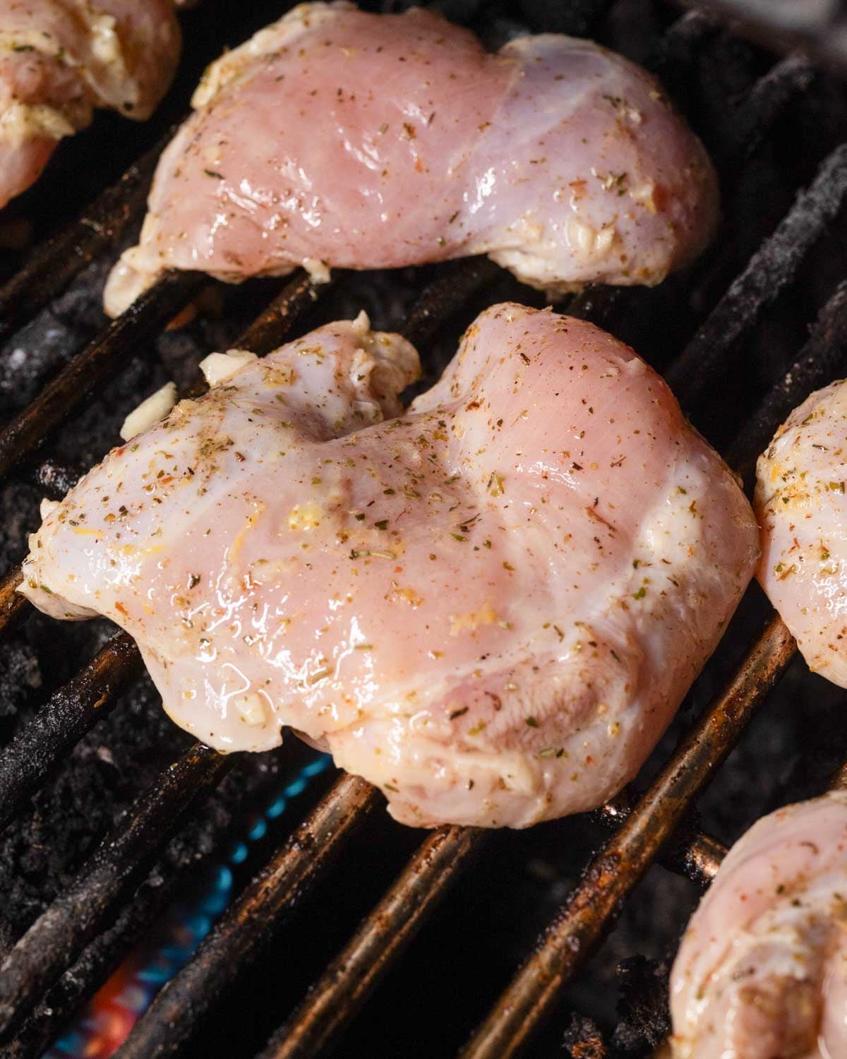 Lemon marinated chicken thighs on a grill.